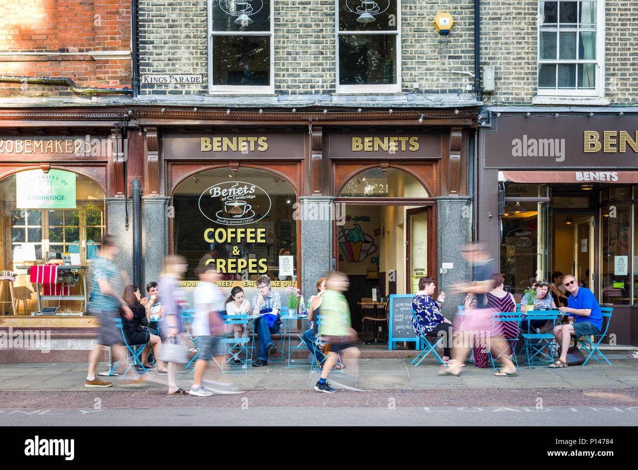 People sitting outside Benets coffee shop as well as walking past on the pavement, Kings Parade, Cambridge, UK Stock Photo
