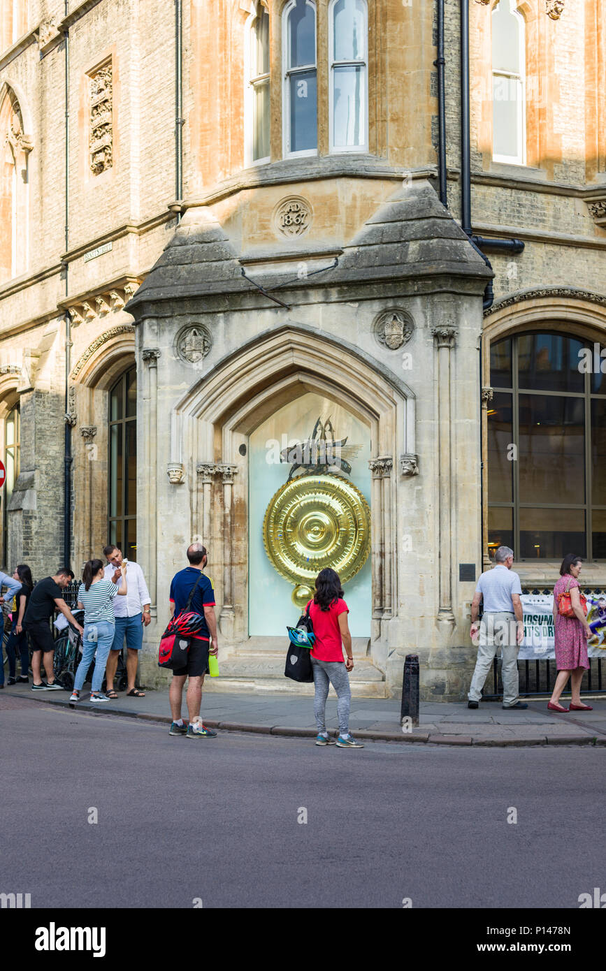 People looking at the Corpus gold handless clock, Cambridge, UK Stock Photo