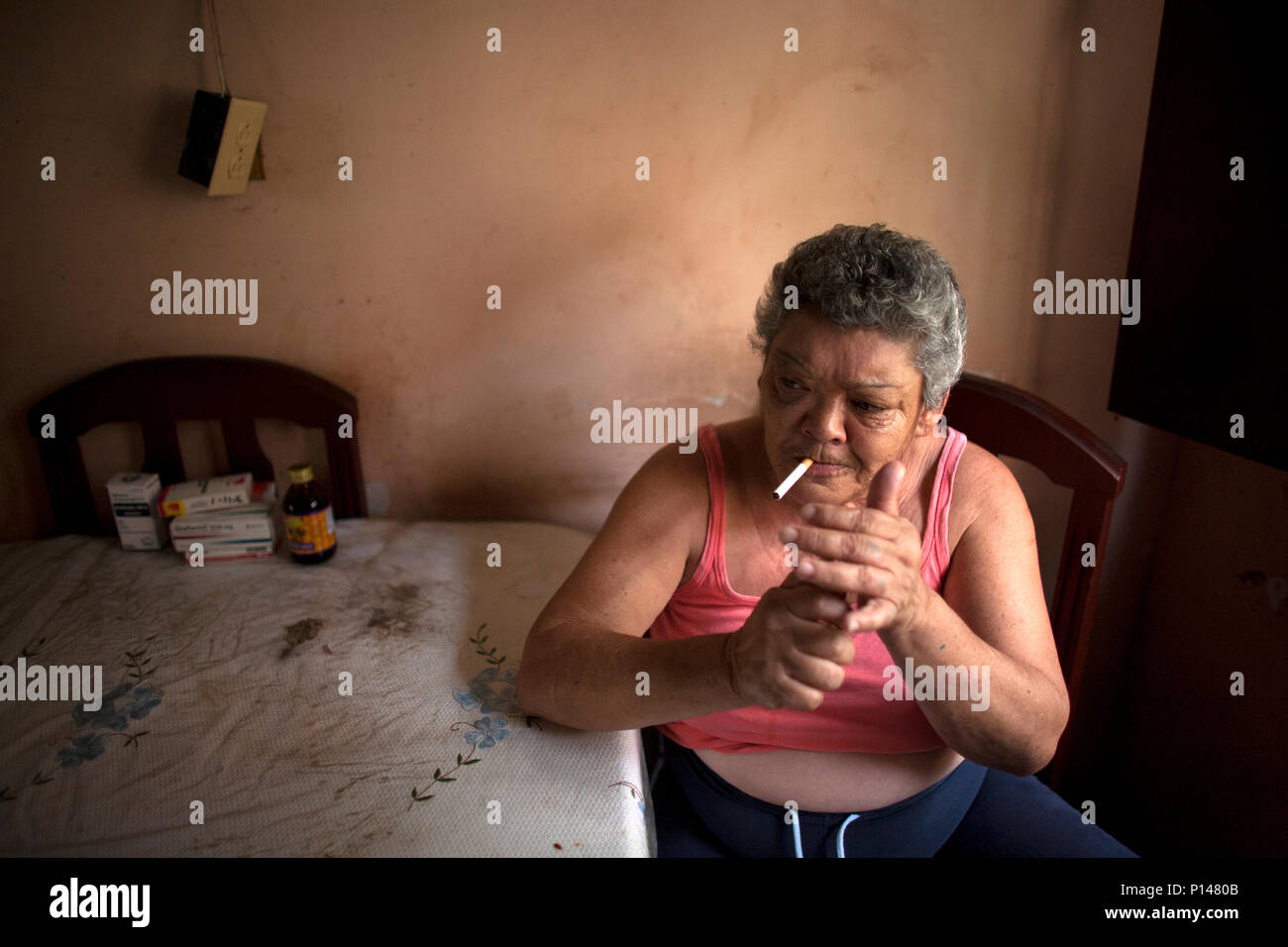 Emperatriz Santiago smokes a cigarette in her home in Los Erasos shanty neighborhood in Caracas, Venezuela, July 22, 2008. Emperatriz lives with her s Stock Photo