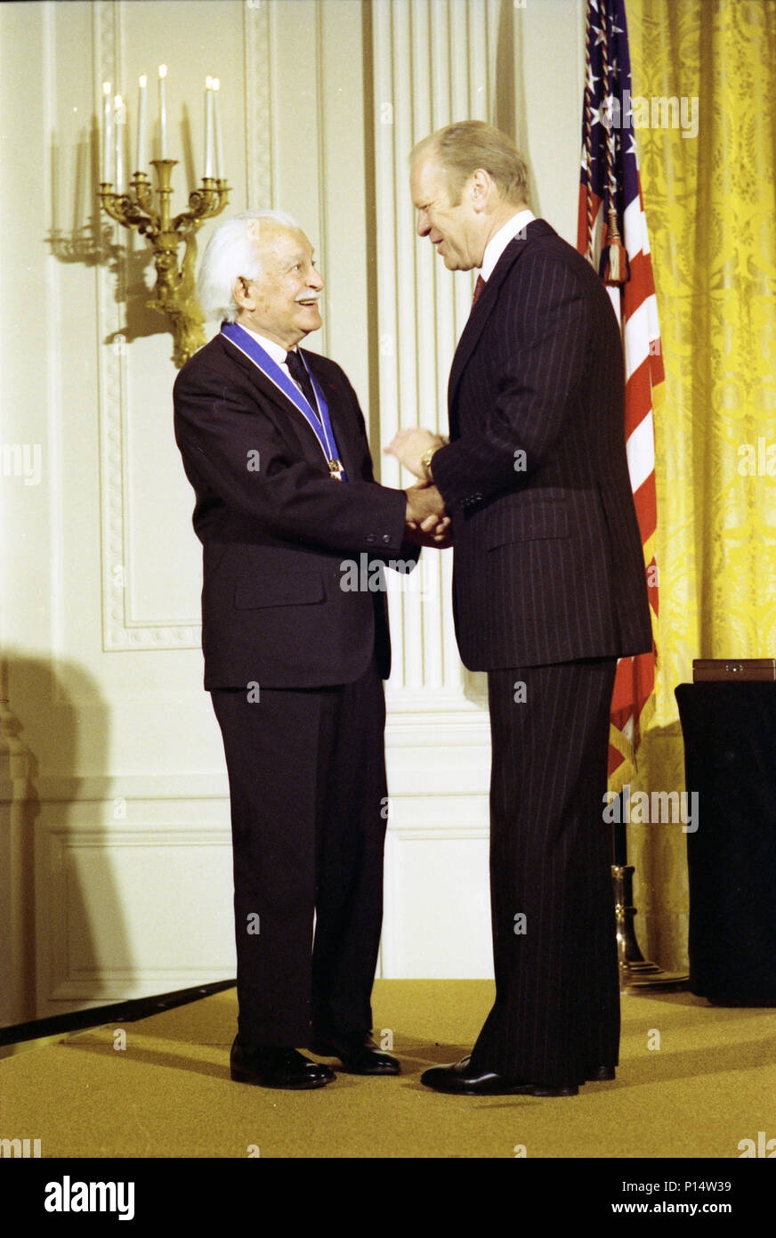 1977, January 10 – East Room – The White House –  Gerald R. Ford, Arthur Fiedler – on stage, handshaking, talking; Fiedler wearing medal – Presidential Medal of Freedom Presentation Ceremony - Violinist, Conductor Stock Photo