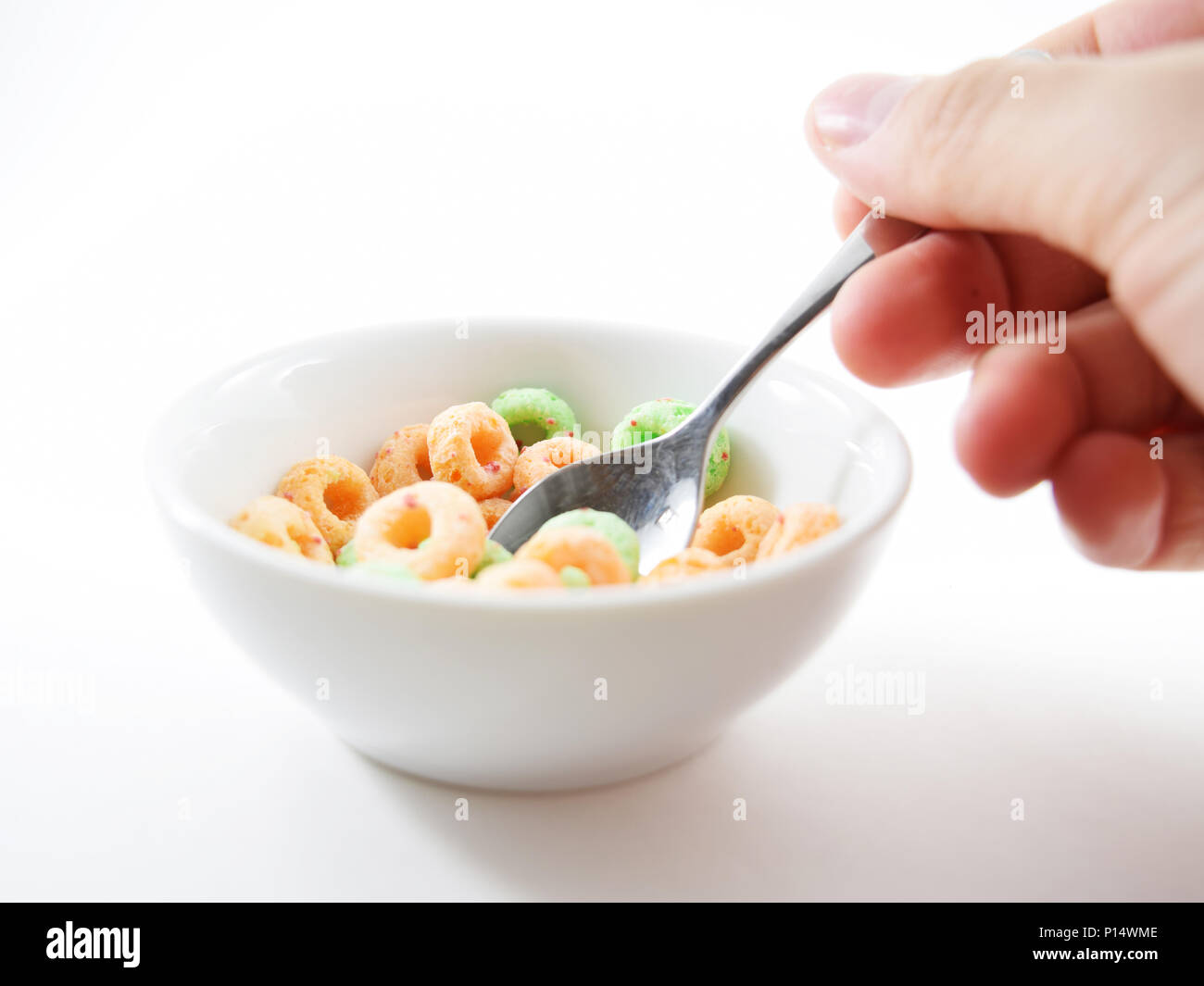 Small spoon scooping colored oshaped sugary cereal Stock Photo Alamy