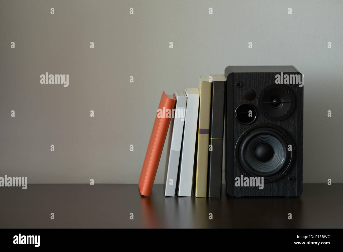 bookshelf speaker with books on a TV stand Stock Photo Alamy