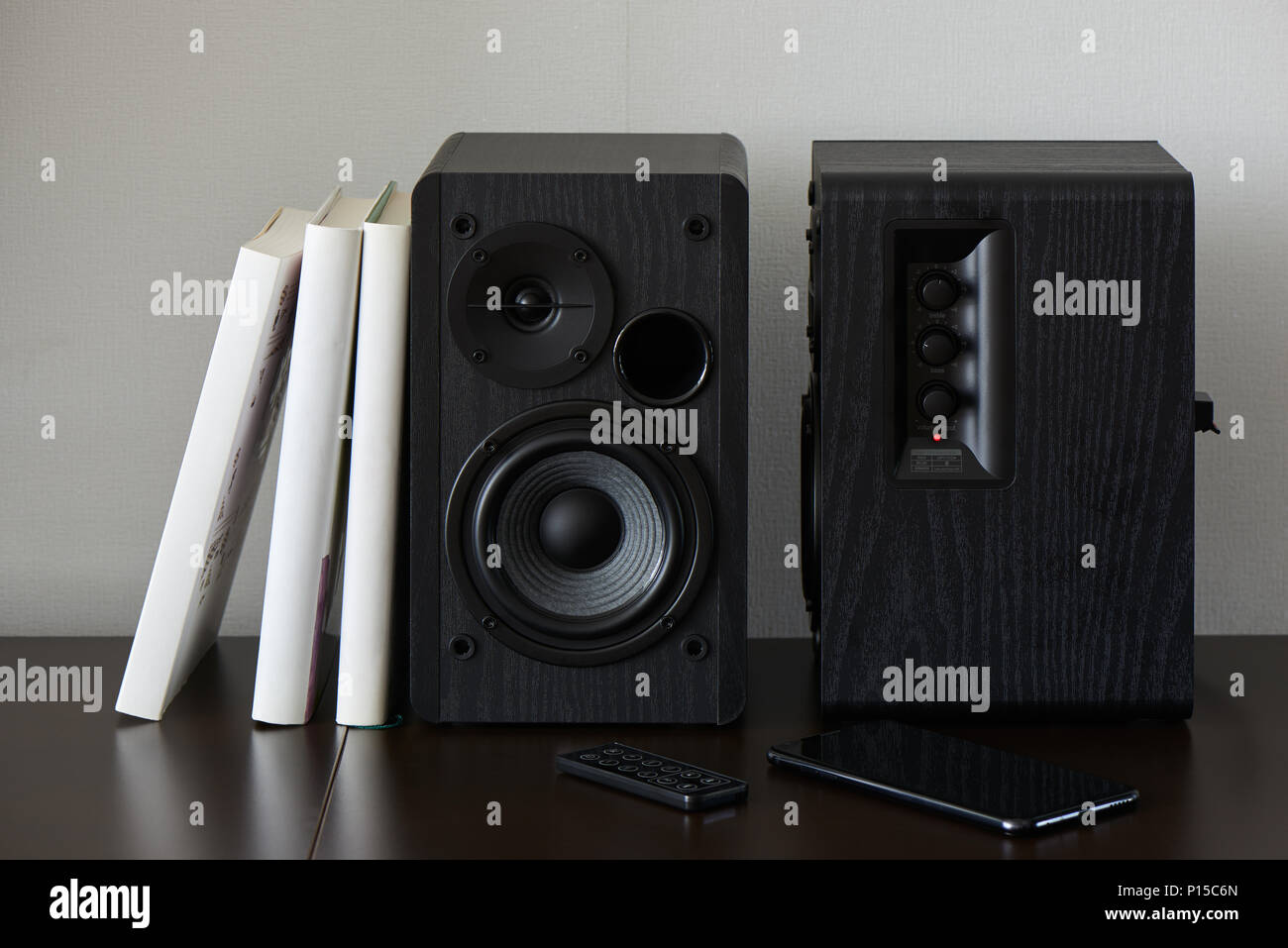 bookshelf speaker with books, smartphone and remote controller on a TV stand Stock Photo Alamy