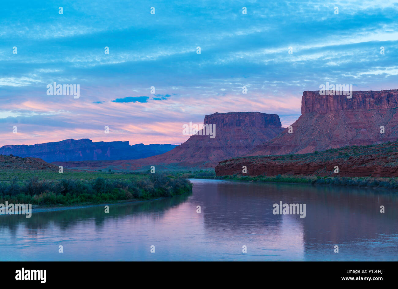 Pink sunset along Colorado River with two butte rock formations located near Moab and Arches National Park, Utah, USA. Stock Photo
