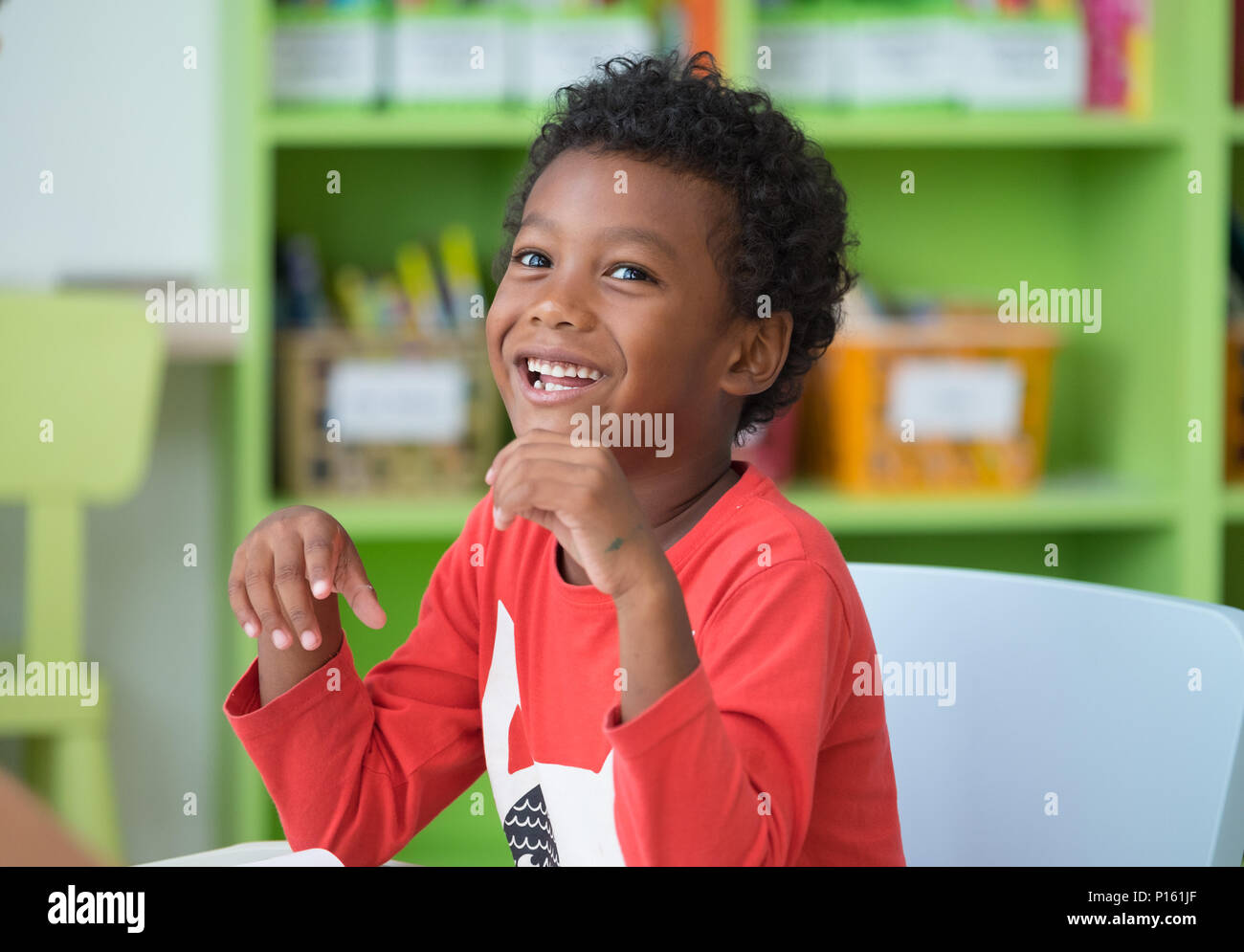 African American ethnicity kid smiling at library in kindergarten ...