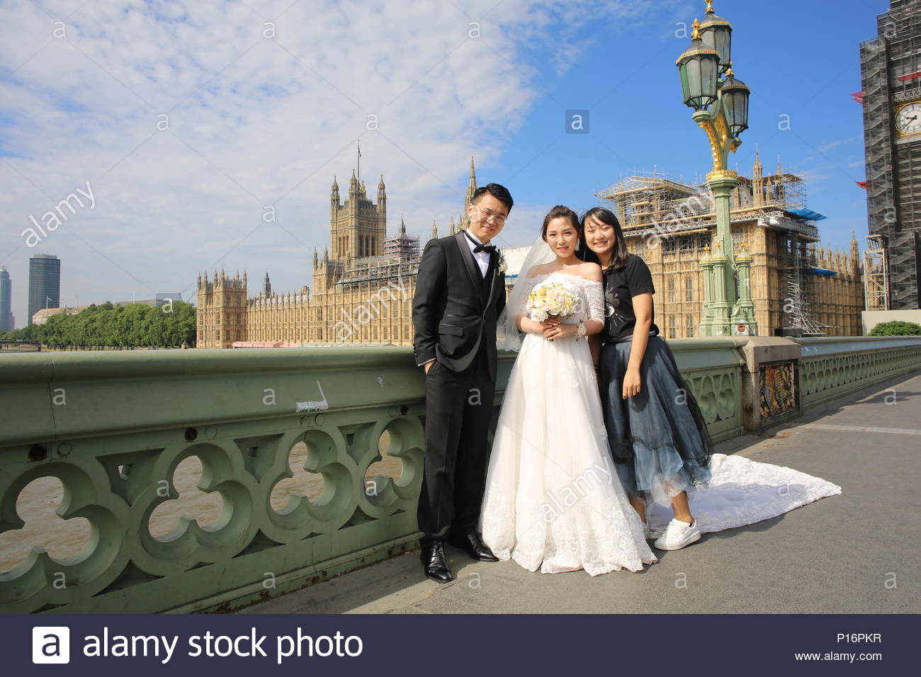 London, UK. 11th June 2018. There was glorious weather in London this morning as early grey skies cleared and brought sunshine to the banks of the Thames. Ideal weather for any one getting married as are Hai and Miao who came to Westminster Bridge with a friend to take wedding photographs. Credit: Clearpix/Alamy Live News Stock Photo