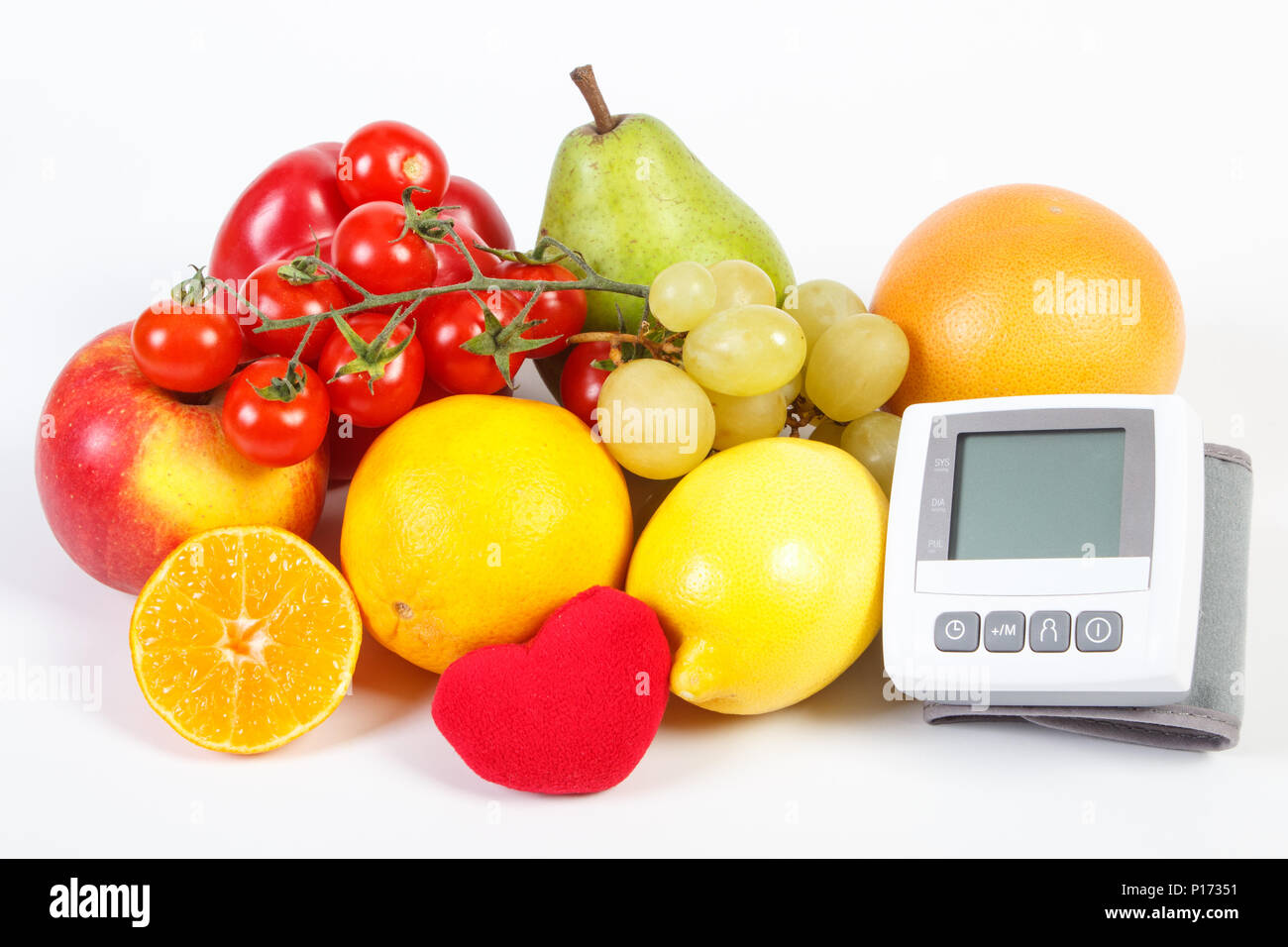 Blood pressure monitor and fresh fruits with vegetables, concept of ...