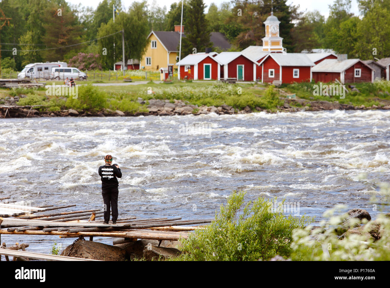 Kukkola, Finland - JUly 3, 2017: A tourist with a camera at the Kukkola rapids in the Torne river at the Finno-Swedish border. Stock Photo