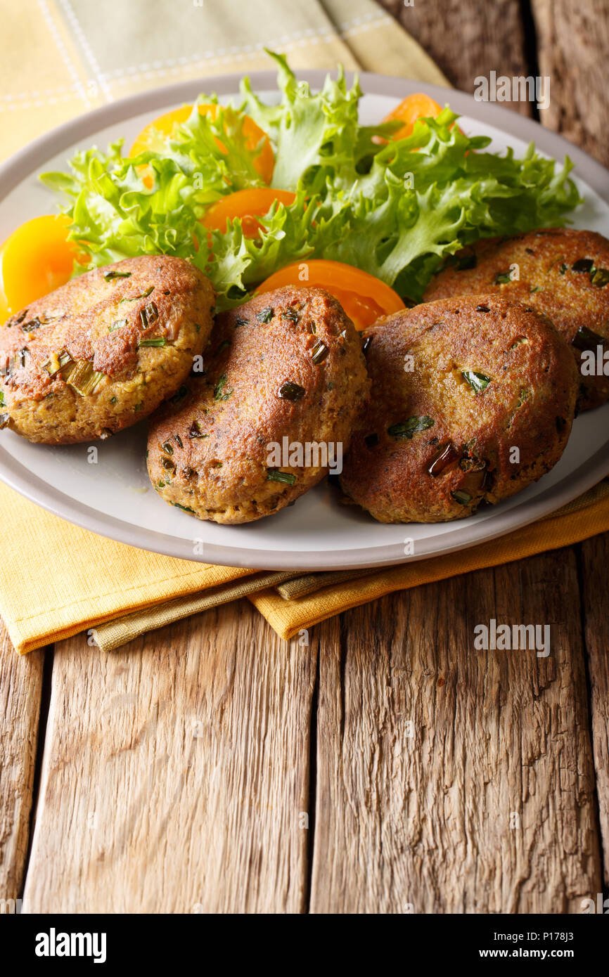 Tuna patties with herbs and fresh vegetable salad close-up on a plate on the table. vertical Stock Photo