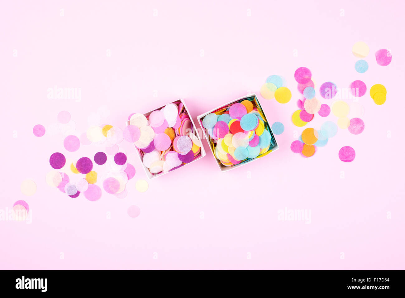 Two boxes with colorful confetti on pink background. Festive banner. Top view. Stock Photo