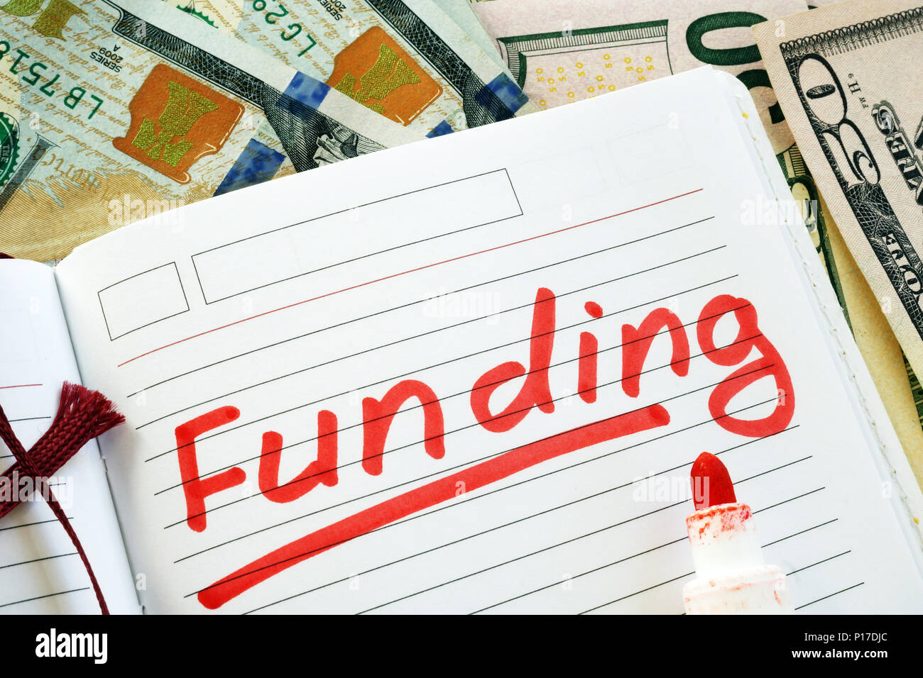 Hand is writing Funding in the note. Stock Photo