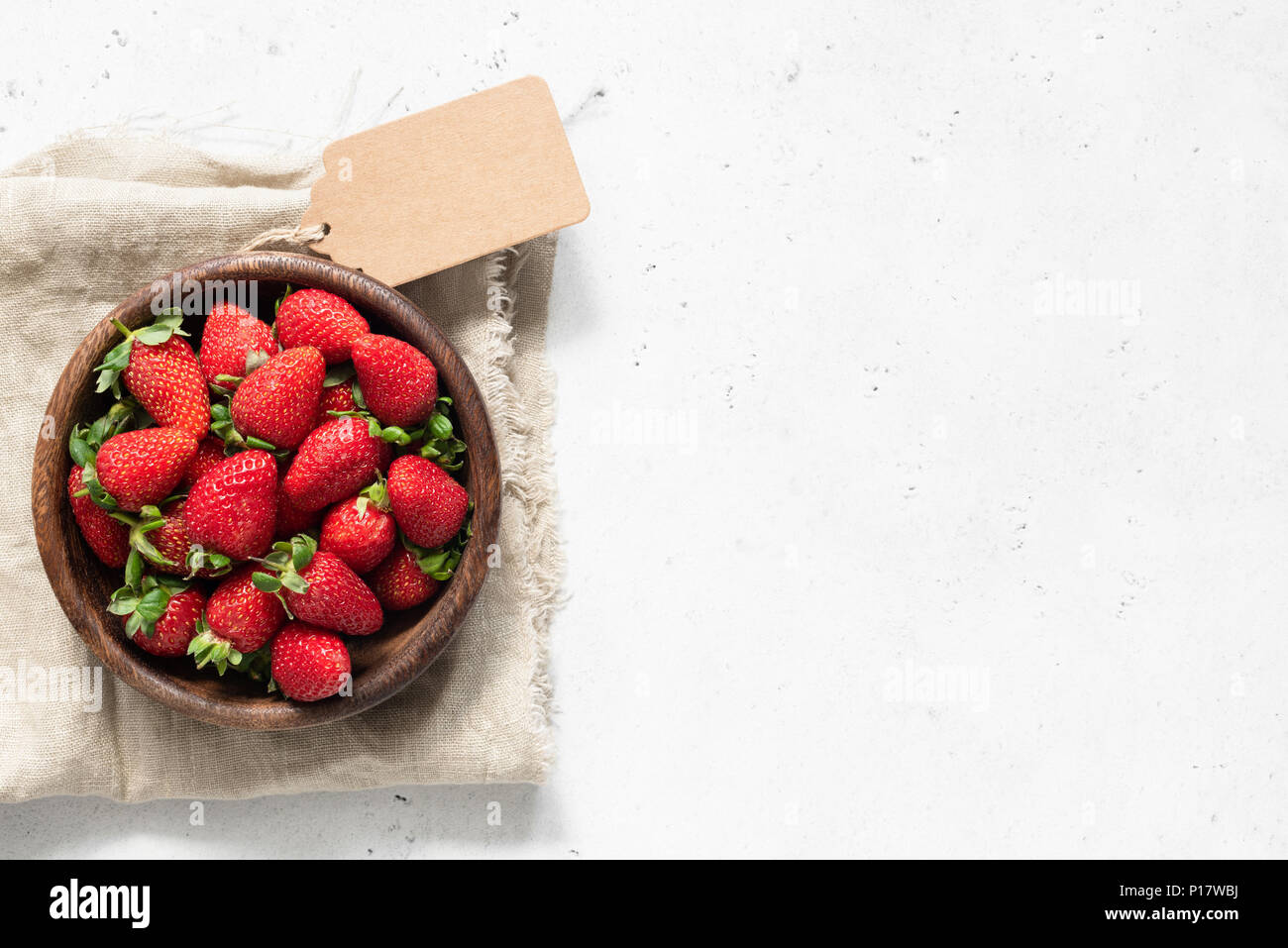 Strawberry in bowl. Fresh strawberries on white concrete background. Top view with copy space for text Stock Photo