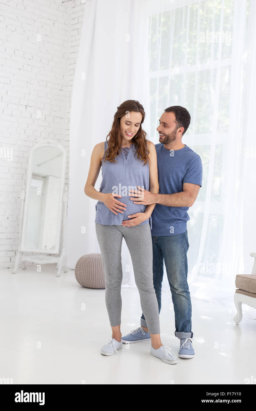 Happy man hugging pregnant woman Stock Photo - Alamy