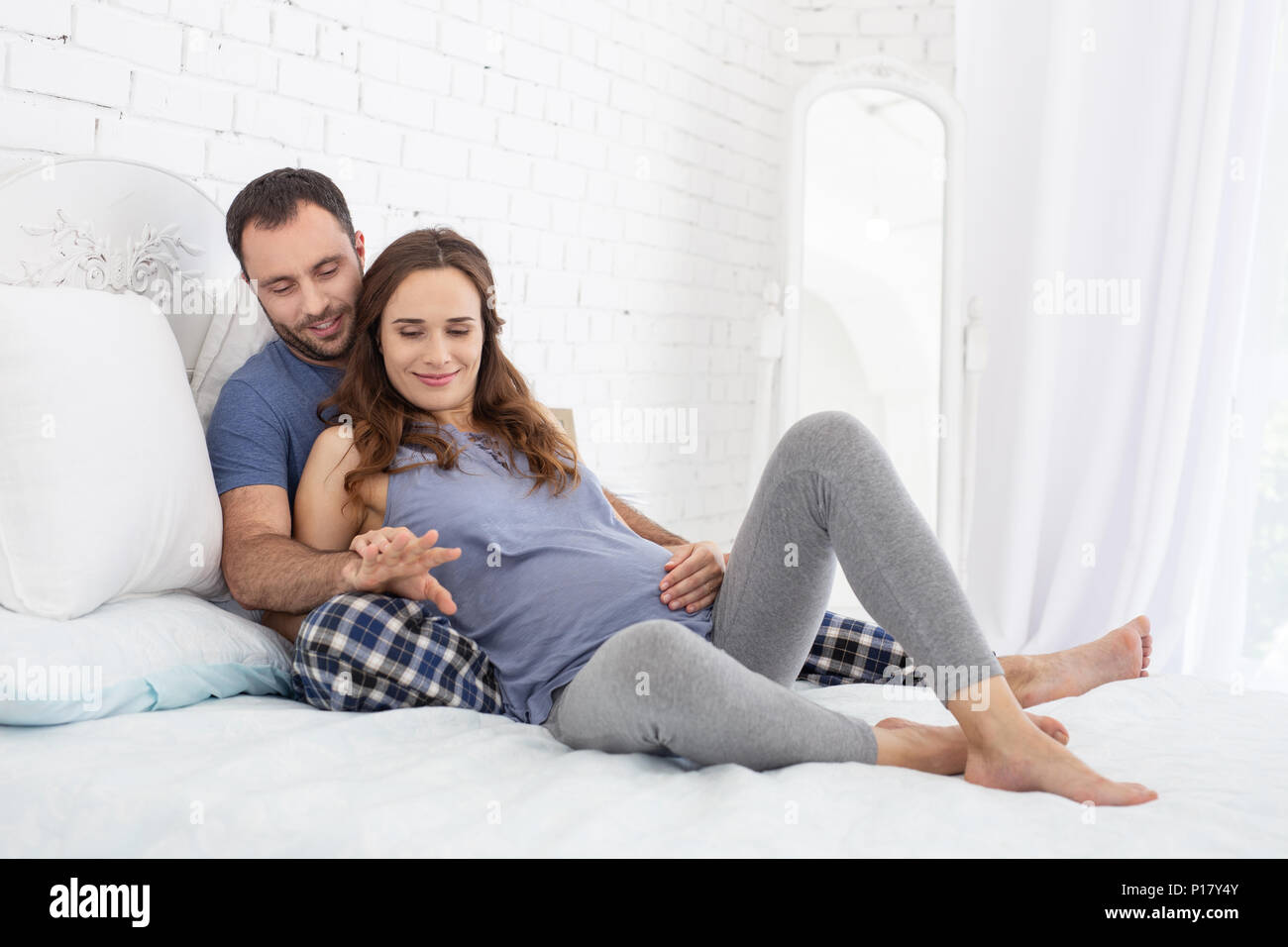 Happy man embracing pregnant woman Stock Photo - Alamy