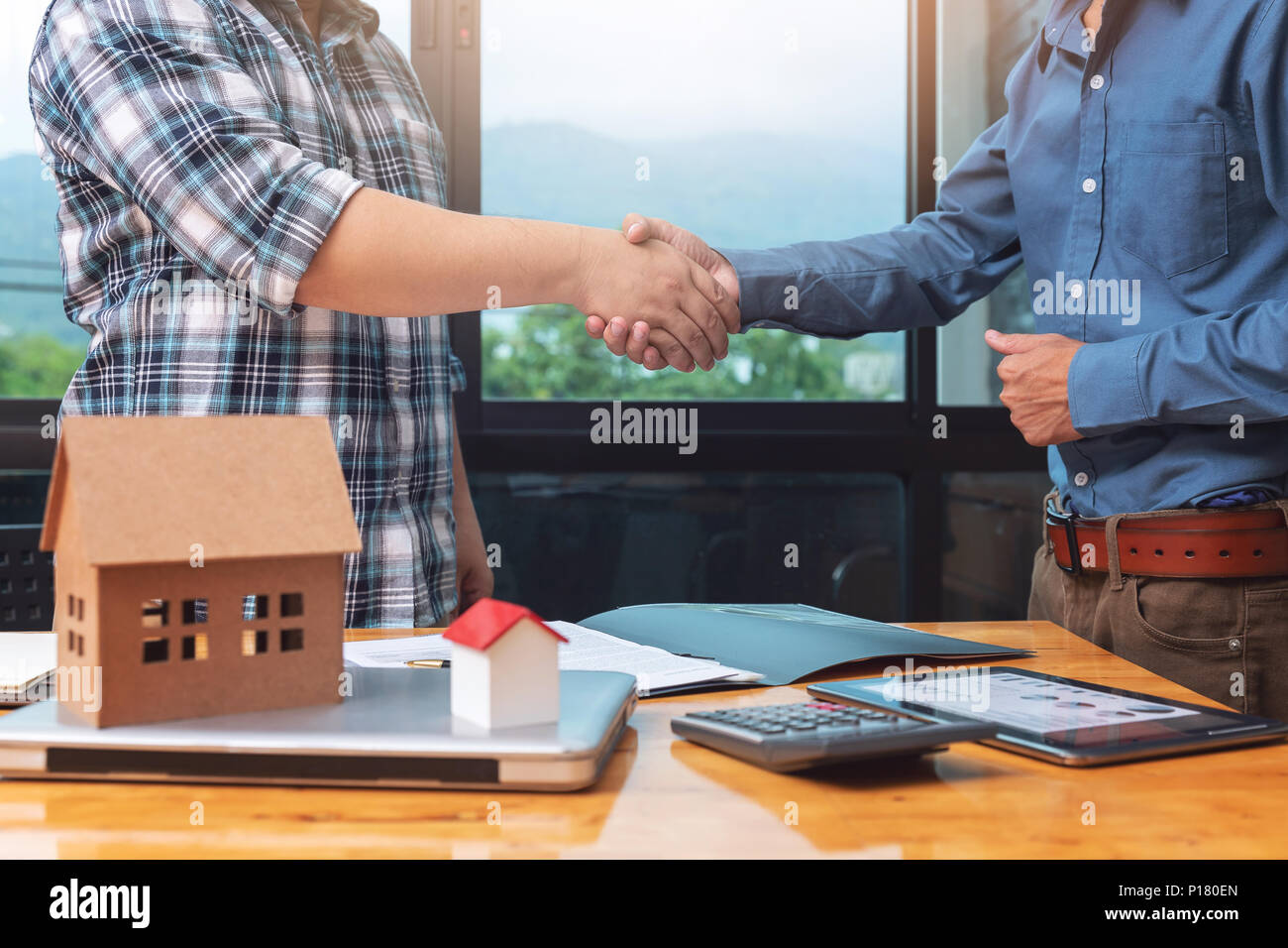 Real estate agent shaking hands with his client after sealing deal. Stock Photo