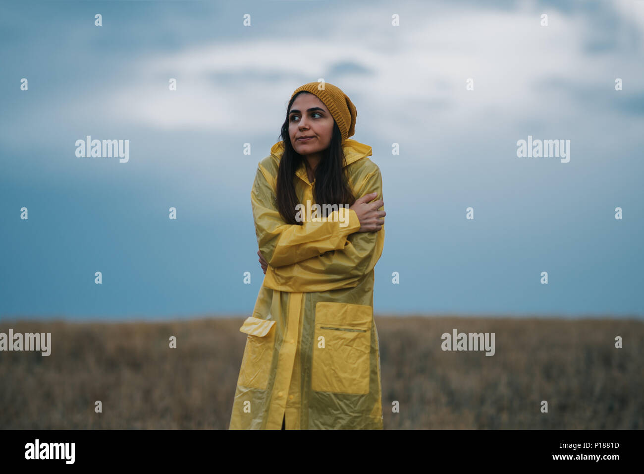 Young girl wearing a yellow raincoat in rainy and cold day Stock Photo