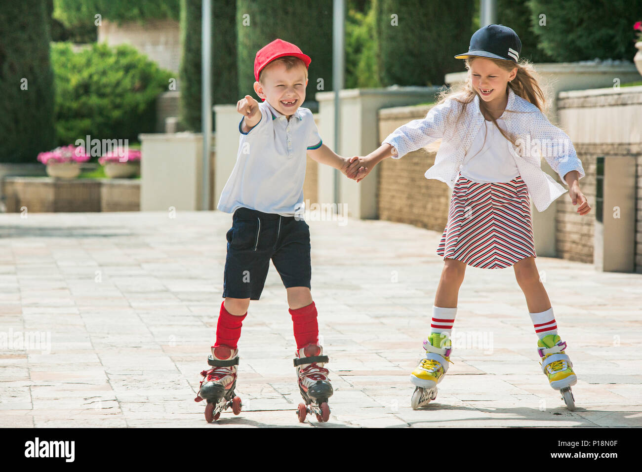 Portrait of a charming teenage couple rollerskating together Stock