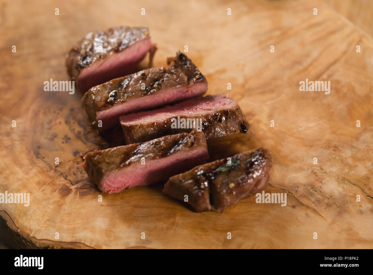sliced medium filet mignon on wood board Stock Photo