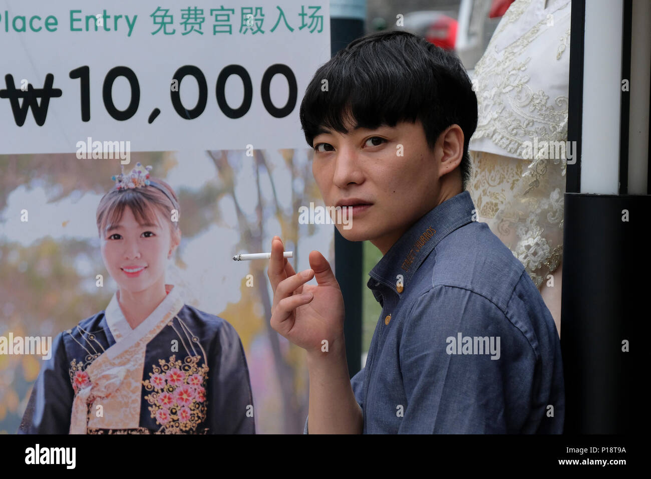 Young Korean man smoking a cigareete in the street in the city of Seoul