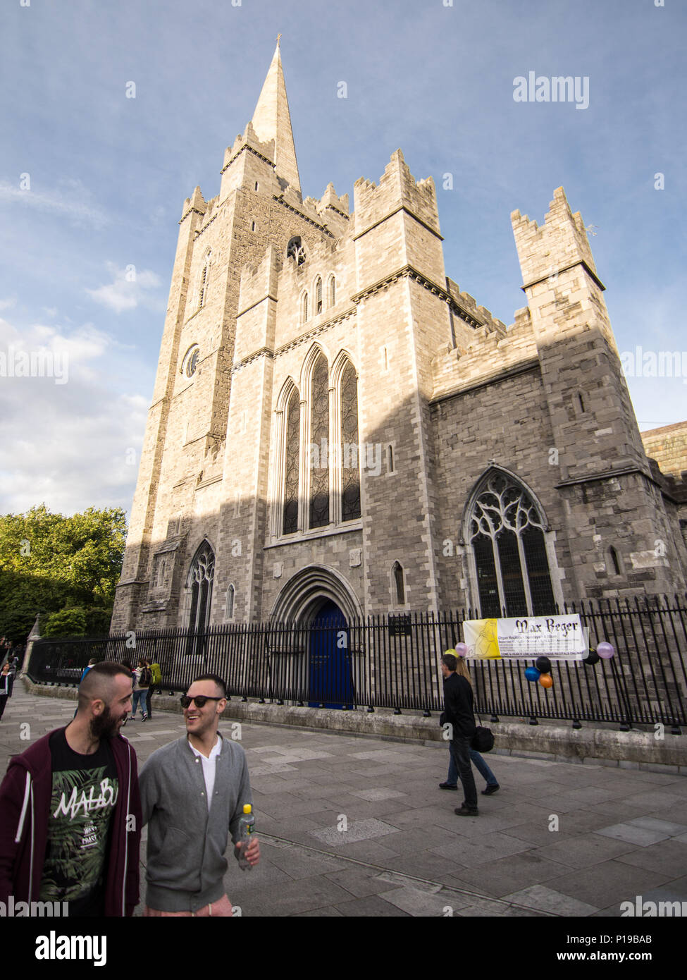 Dublin, Ireland - September 16, 2016: Pedestrians and tourists pass the west front and tower of St Patrick's Roman Catholic cathedral in Dublin. Stock Photo