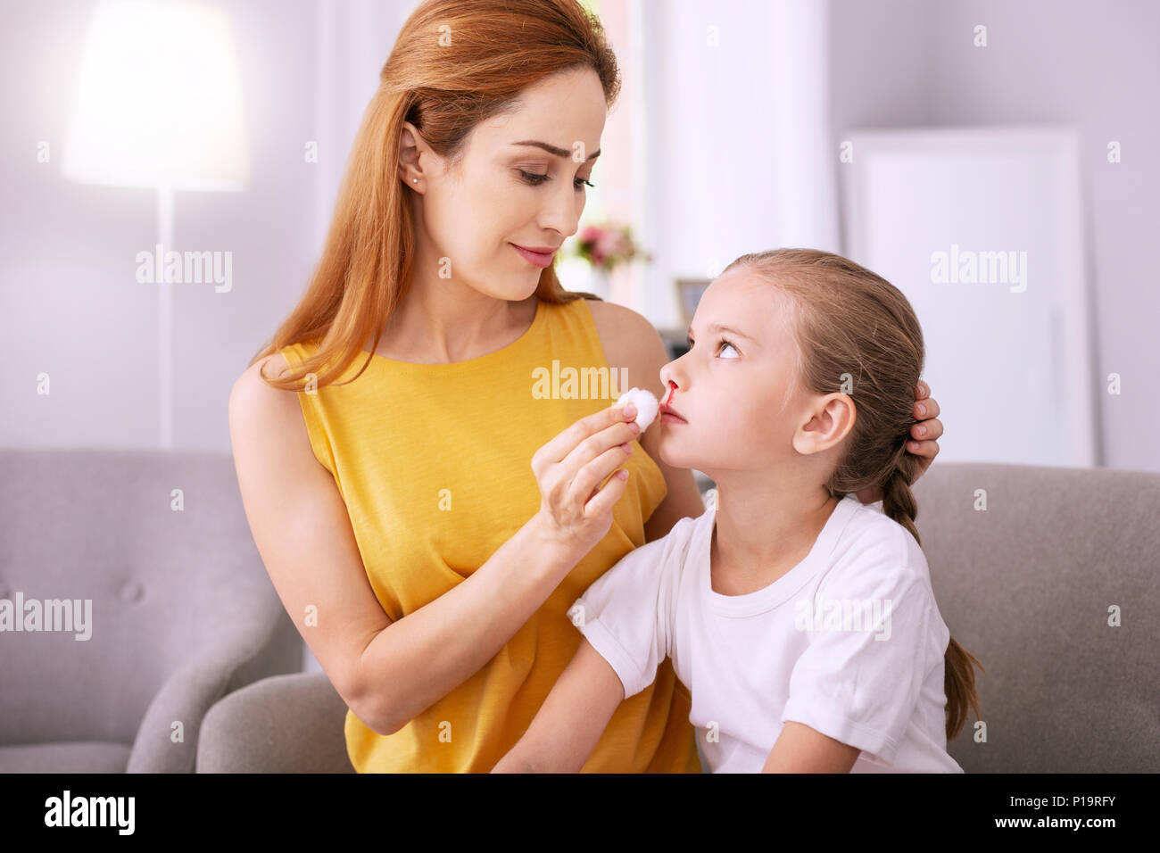 Sad gloomy girl sitting together with her mom Stock Photo