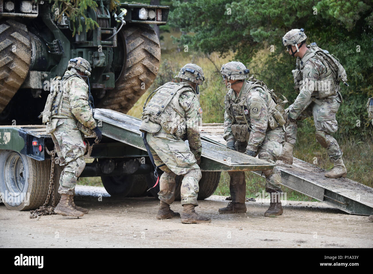 U.S. Soldiers, assigned to Bravo Troop, Regimental Engineer Squadron, 2d Cavalry Regiment, unload a M105 DEUCE-Deployable Universal Combat Earthmover during Exercise Allied Spirit V at 7th Army Training Command’s Hohenfels Training Area, Germany, Oct. 4, 2016. Exercise Allied Spirit includes about 2,520 participants from eight NATO nations, and exercises tactical interoperability and tests secure communications within Alliance members and partner nations.  (U.S. Army photo by Visual Information Specialist Gertrud Zach) Stock Photo