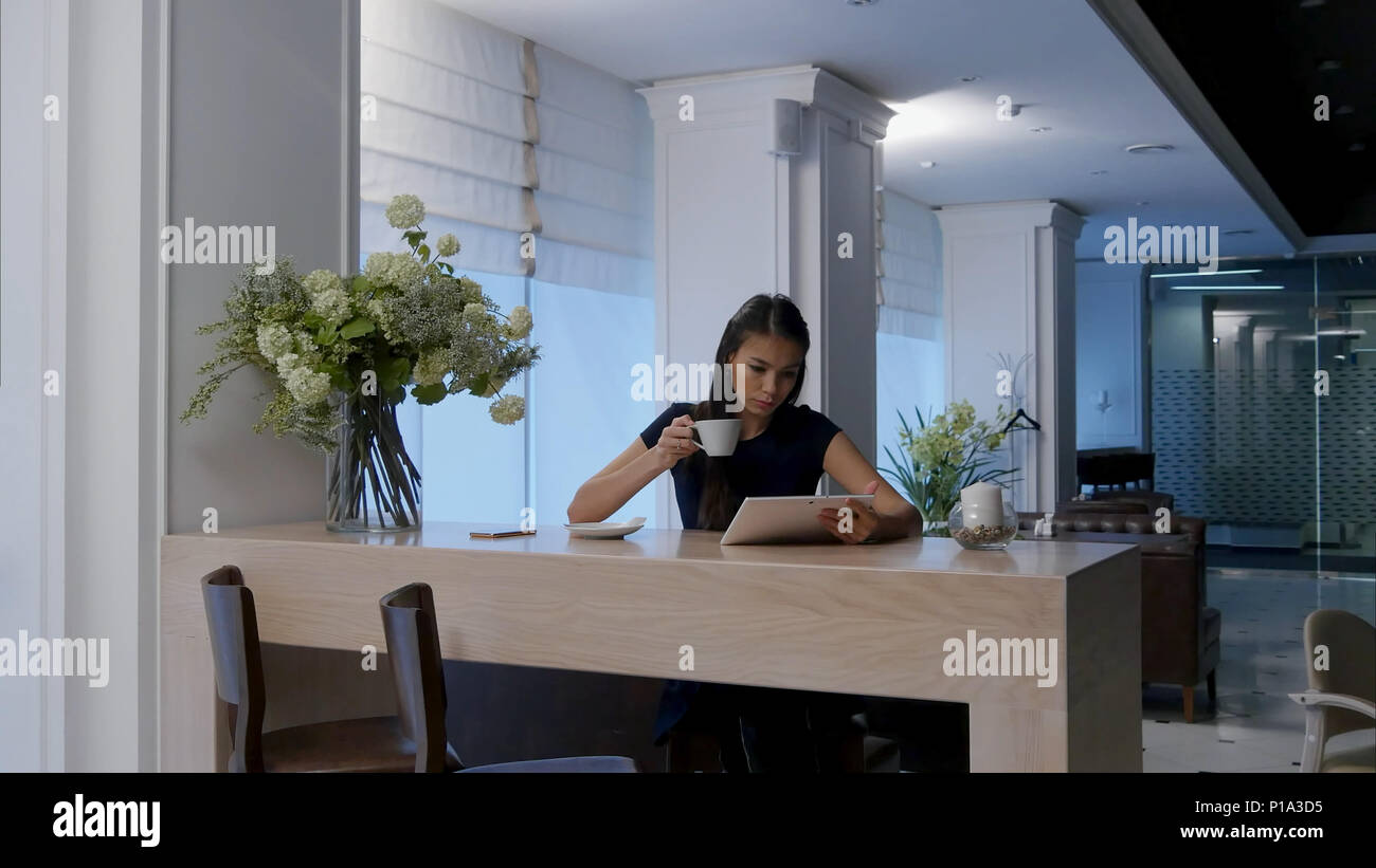 Young woman using digital tablet while drinking coffee at a cafe Stock ...