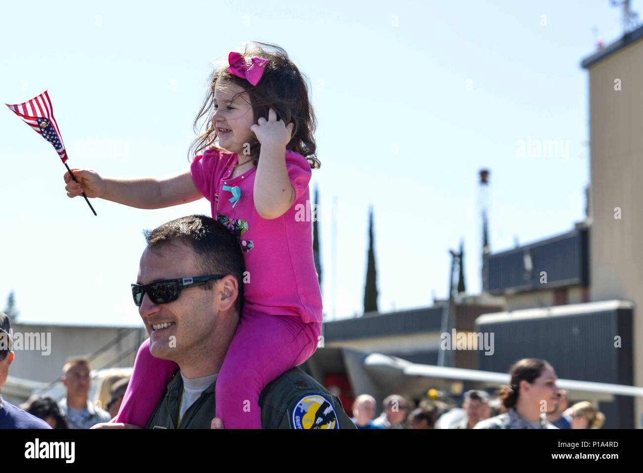 U.S. Air Force Maj. Luke Campagne, 194th Fighter Squadron F-15 pilot, and  his daughter, Tatum, wait for F-15 Eagles to land at the Fresno Air  National Guard Base Oct. 2, 2016. Nine