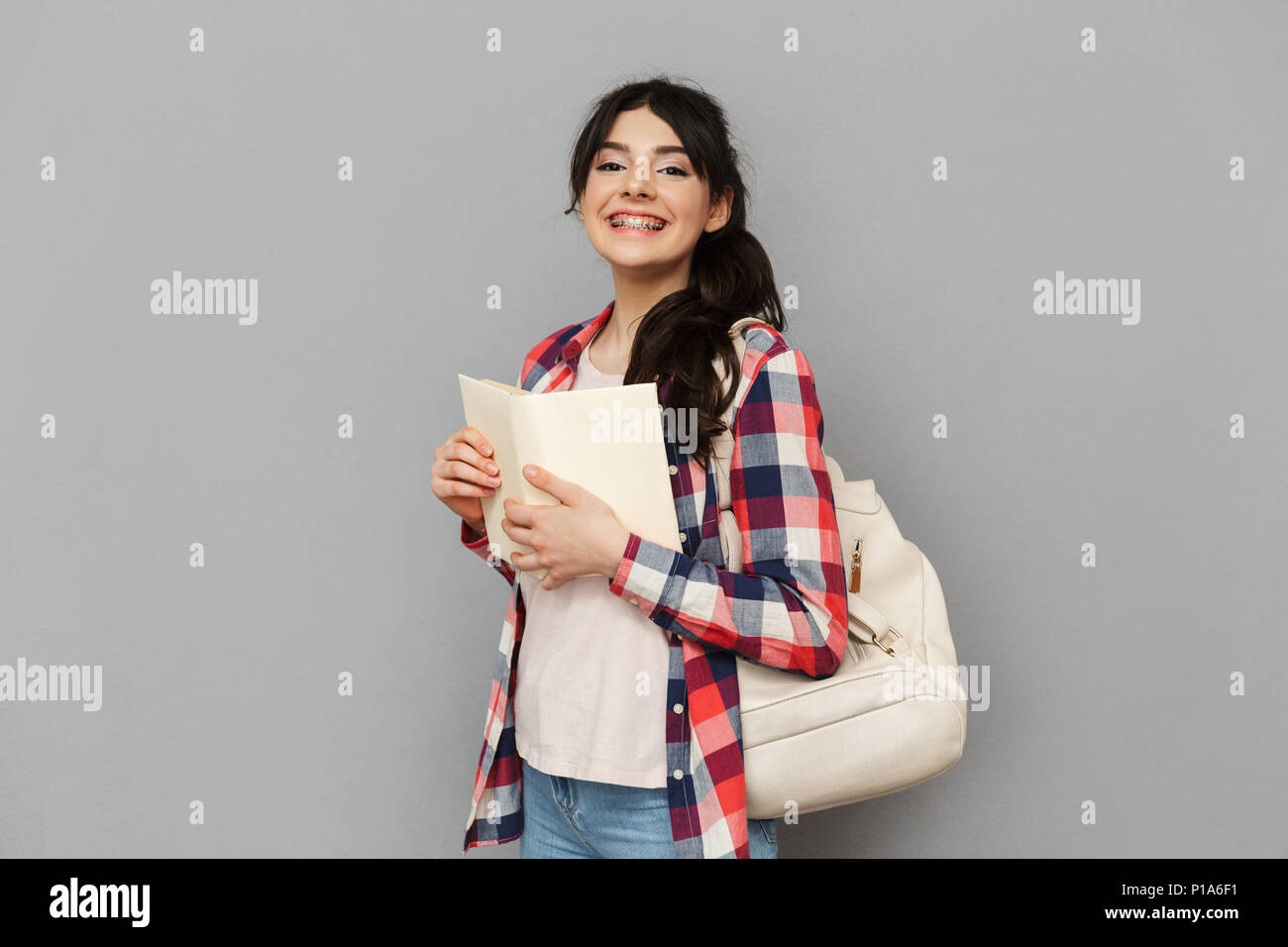 Image of pretty cute young lady student standing isolated over grey ...