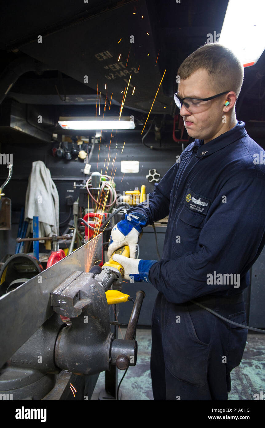 161005-N-WS581-083  ARABIAN GULF (Oct. 5, 2016) Petty Officer 3rd Class Jacob Keller, from Marshall, Ill., uses a grinder to dull the edges of a piece of metal in the repair shop of the aircraft carrier USS Dwight D. Eisenhower (CVN 69) (Ike). Keller serves aboard Ike as hull maintenance technician and is responsible for metal fabrication and shipboard metalwork maintenance. Ike and its Carrier Strike Group are deployed in support of Operation Inherent Resolve, maritime security operations and theater security cooperation efforts in the U.S. 5th Fleet area of operations. (U.S. Navy photo by Pe Stock Photo