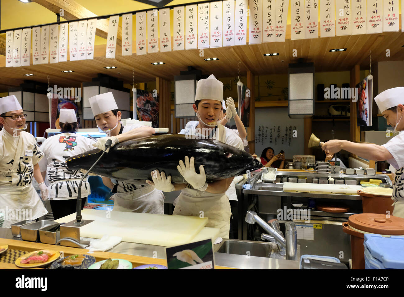 Cookers carrying a large tuna fish in a Japanese restaurant inside