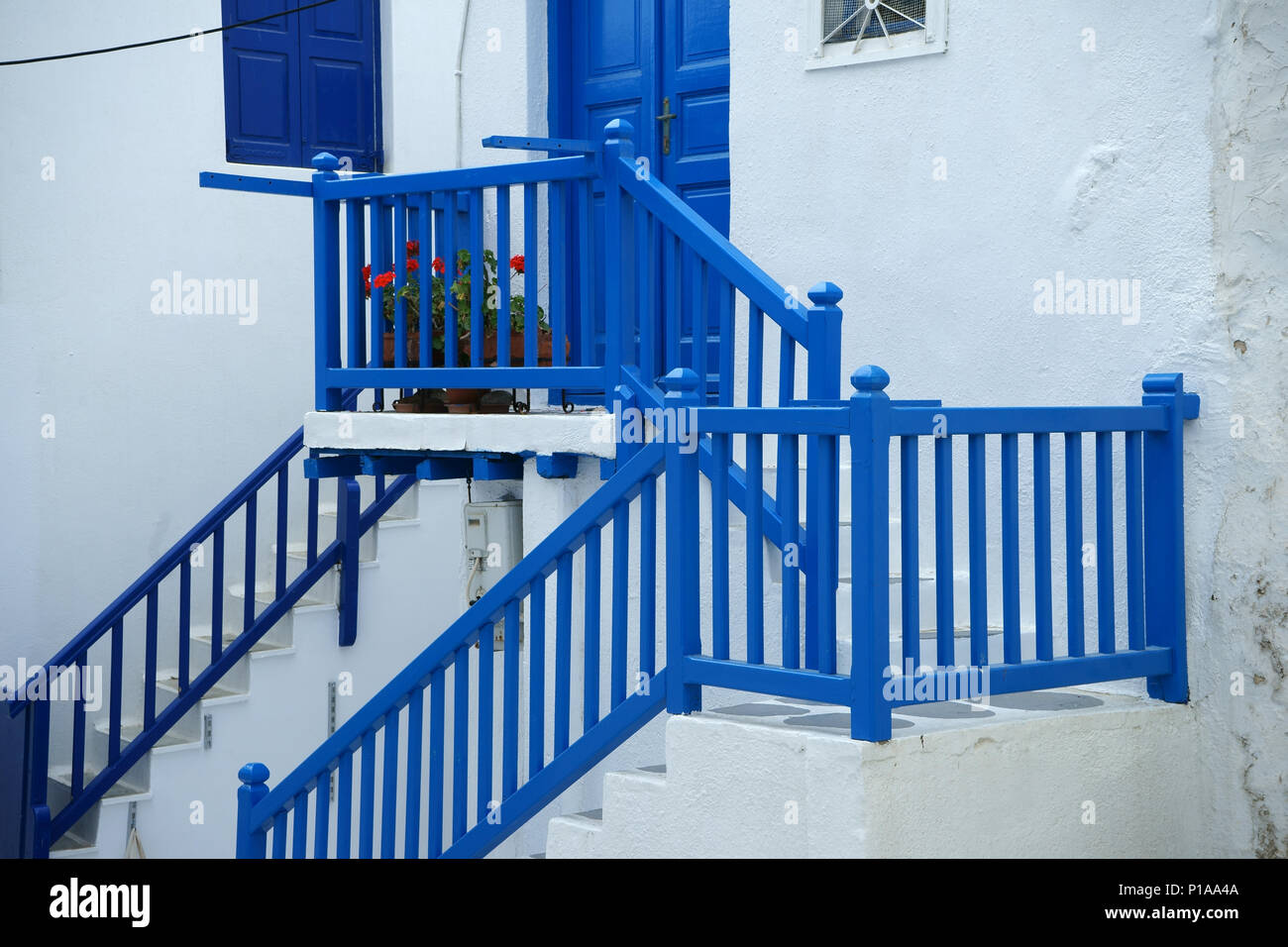 Stair with blue railing leading to blue door of house, town Mykonos, Cyclades islands, Greece Stock Photo