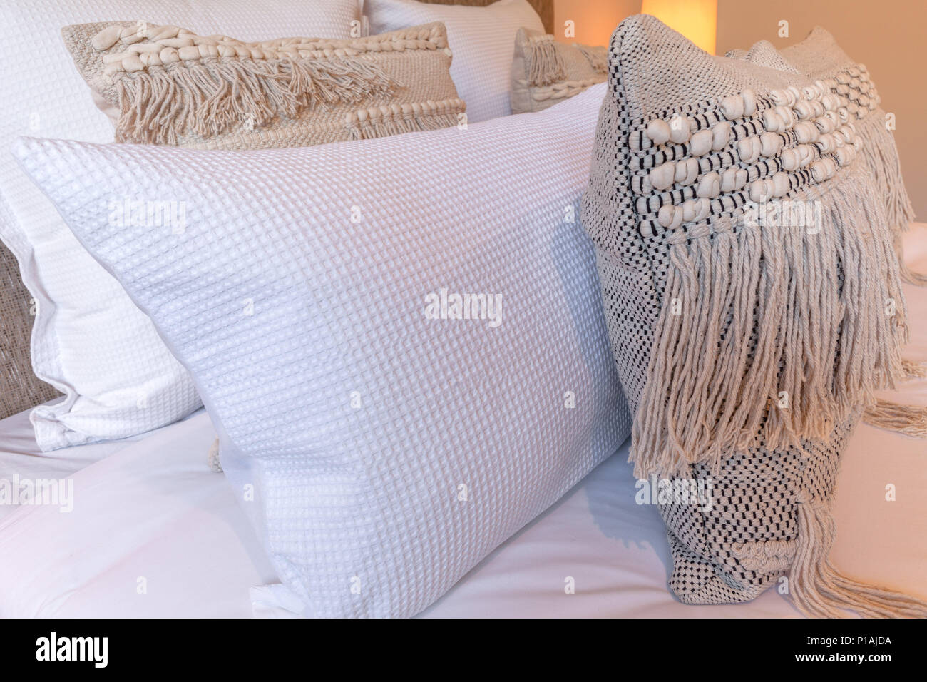Close-up of decorative pillows on a bed in bedroom Stock Photo