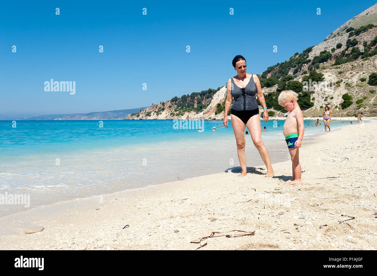 Two year old boy with his grandmother on a beach, Ag. Kiriakis beach, Kefalonia, Ionian Islands, Greece, Europe Stock Photo