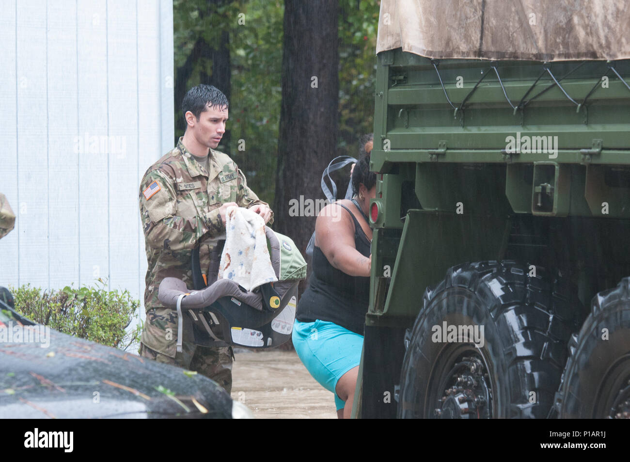 North Carolina Army National Guard Spc. Willard P. Bates, a mechanic with the 230th Brigade Support Battalion evacuates a mother and her infant in Fayetteville, N.C., Oct. 08, 2016. Heavy rains caused by Hurricane Matthew have led to flooding as high as five feet in some areas. (U.S. Army National Guard photo by Staff Sgt. Jonathan Shaw, 382nd Public Affairs Detachment/Released) Stock Photo