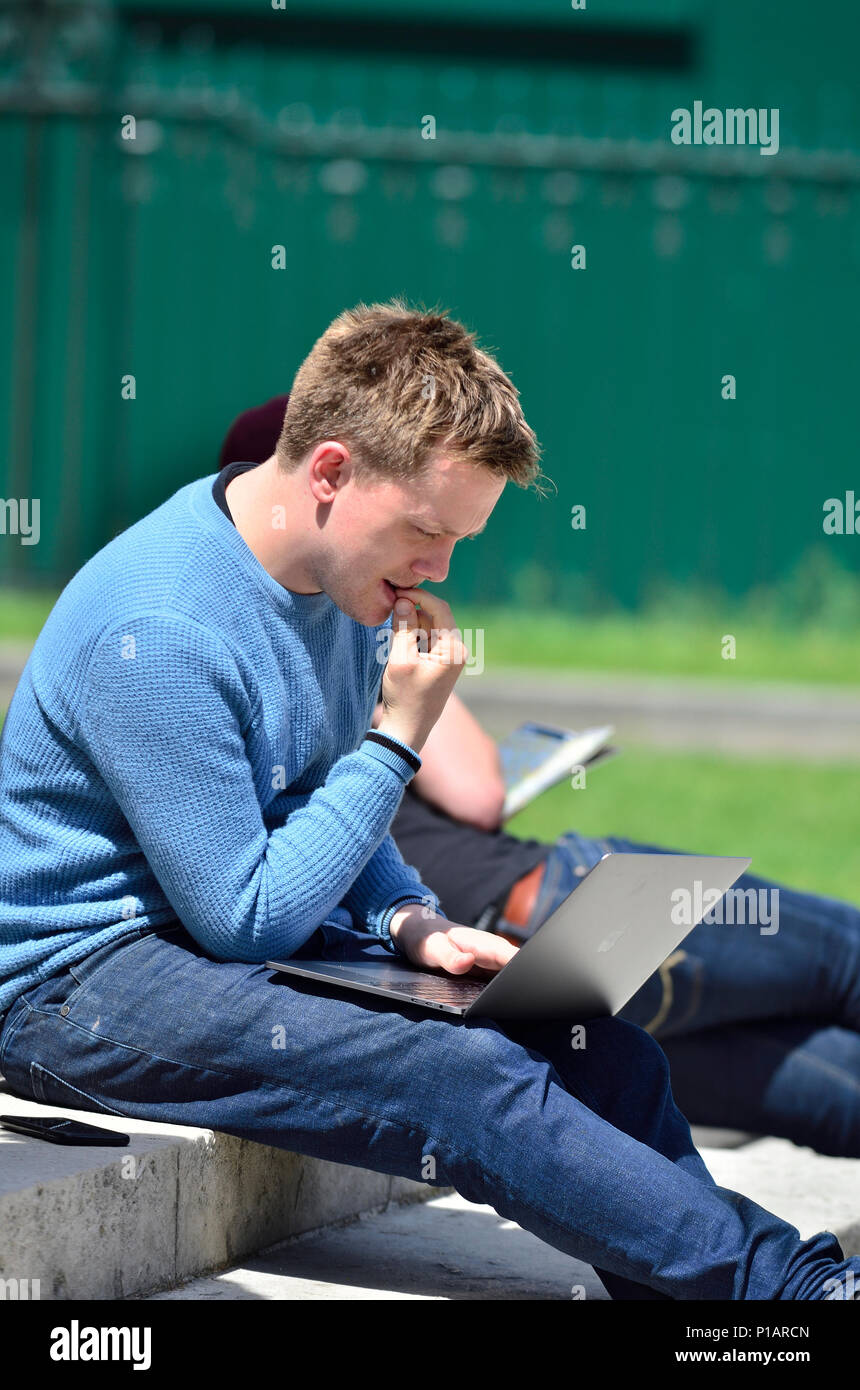 Owen Jones (journalist, writer, left-wing campaigner) working on his laptop at a demonstration in Westminster, June 2018 Stock Photo