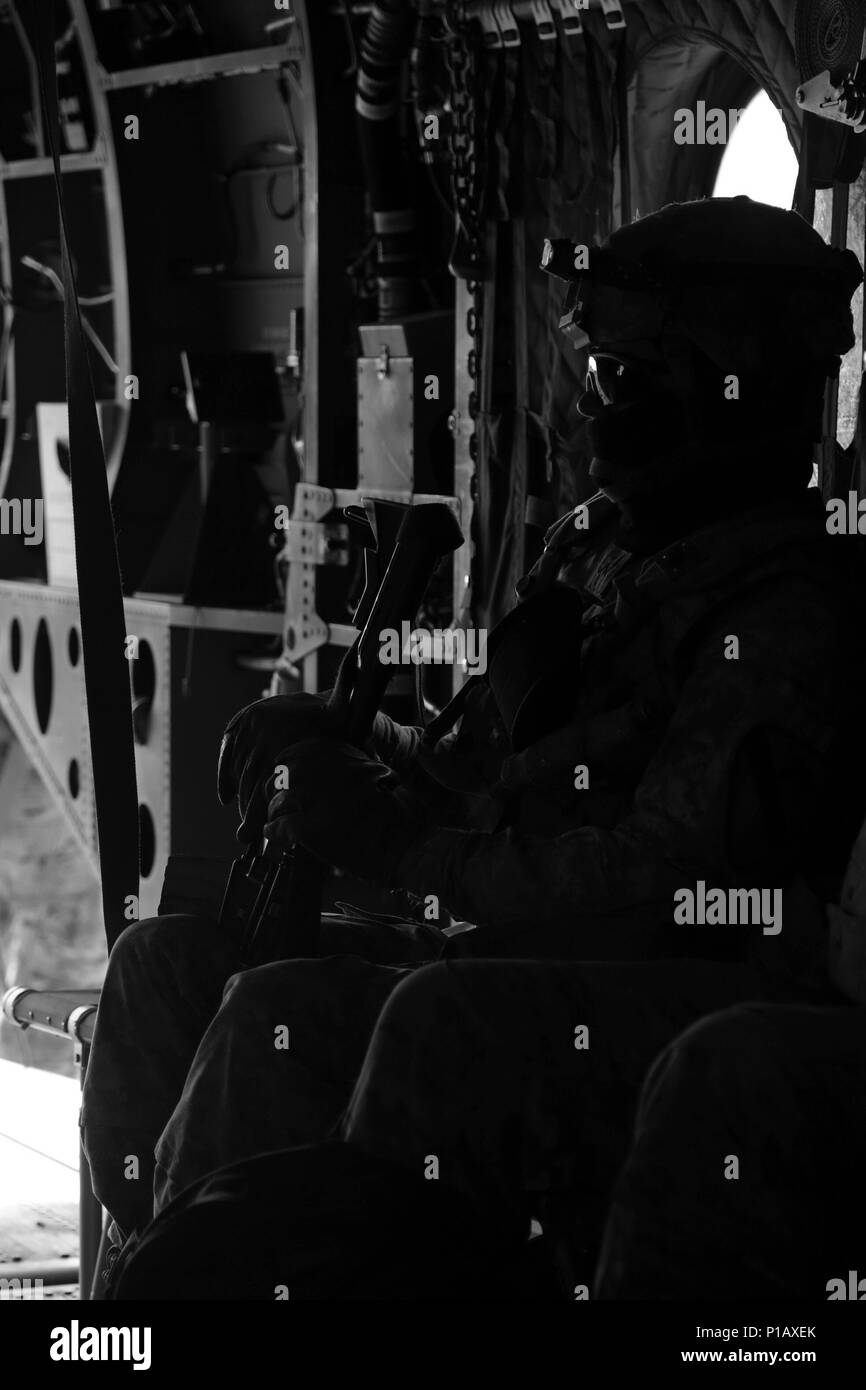 A U.S. Soldier assigned to 1st Battalion, 227th Aviation Regiment, 3rd Brigade Combat Team, 1st Cavalry Division, prepares to take off in a CH-47 Chinook during Decisive Action Rotation 17-01 at the National Training Center in Fort Irwin, Calif., Oct. 3, 2016. Decisive Action Rotations at the National Training Center ensure units remain versatile, responsive, and consistently available for current and future contingencies. (U.S. Army photo by Spc. Daniel Parrott, Operations Group, National Training Center) Stock Photo