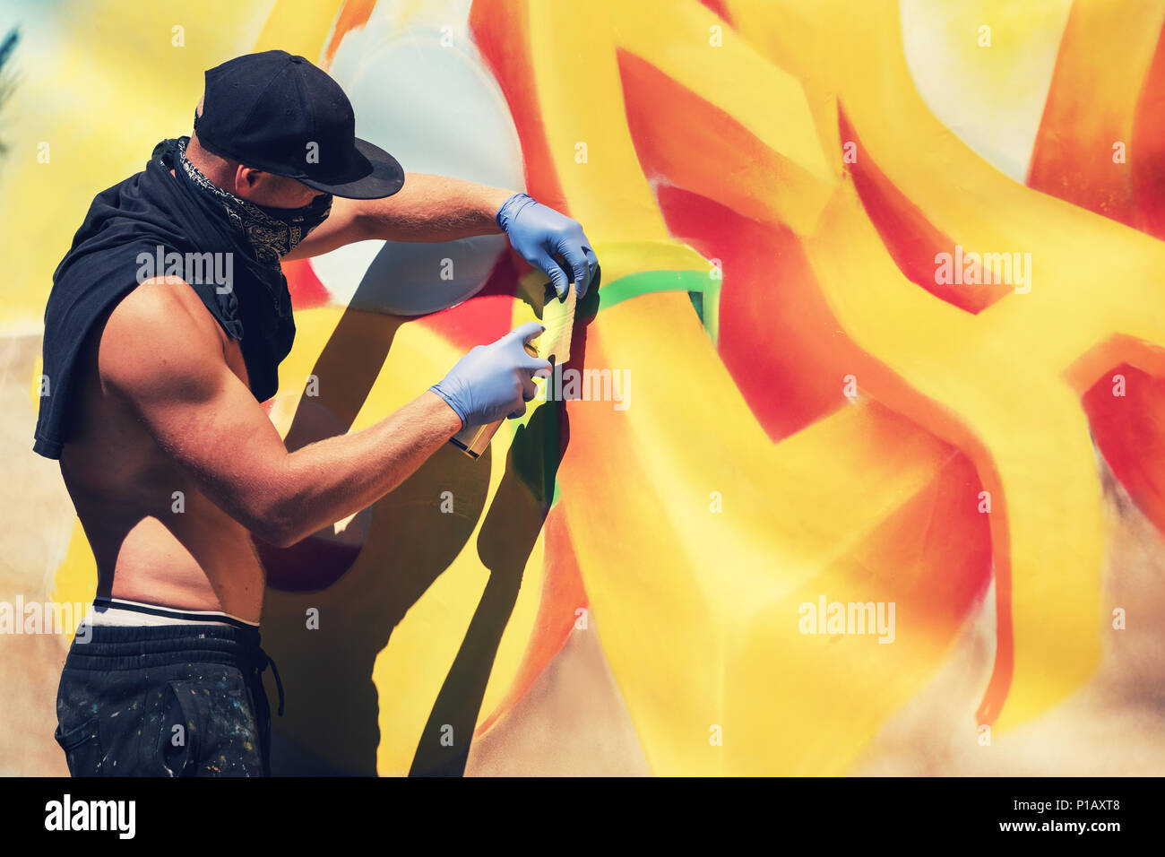 street artist painting colorful graffiti on the wall Stock Photo - Alamy