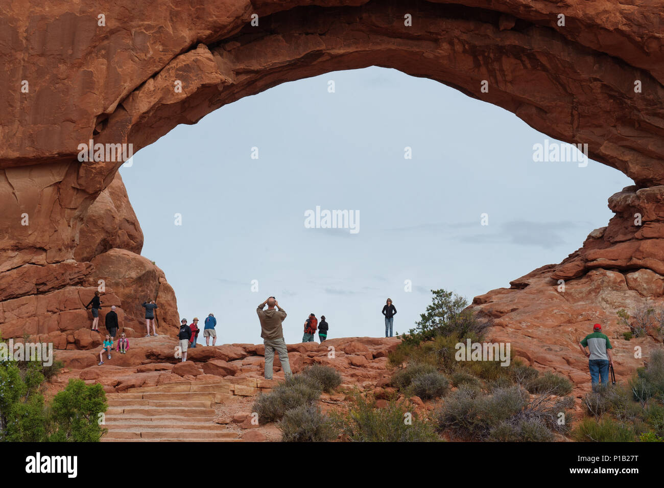 Visitors admiring the North Window Arch at Arches National Park near Moab, Utah, USA. Stock Photo