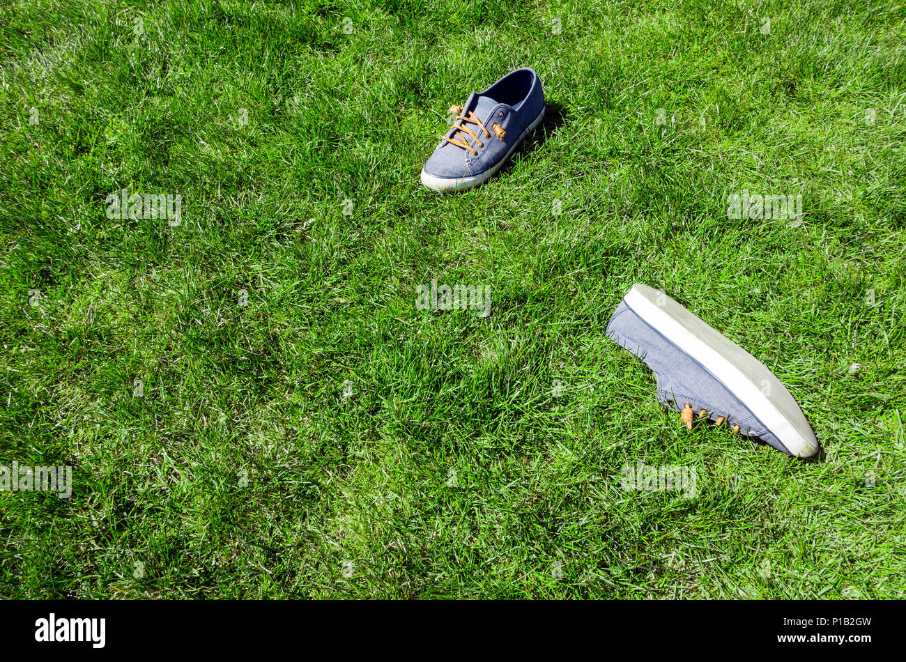 shoes taken off at a lawn green park area on a nice summer day Stock Photo
