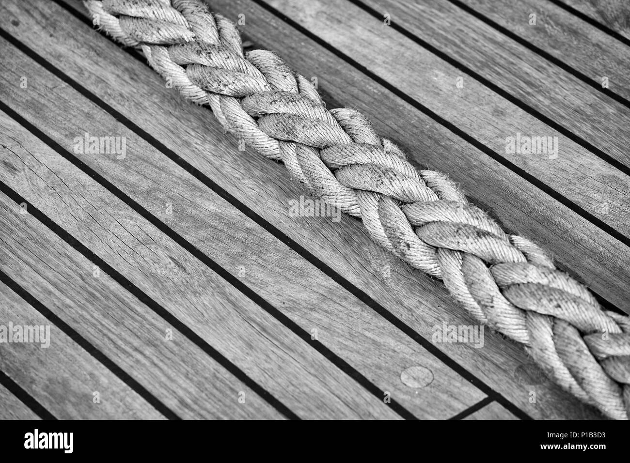Thick rope on an old sailing ship wooden deck, selective focus. Stock Photo