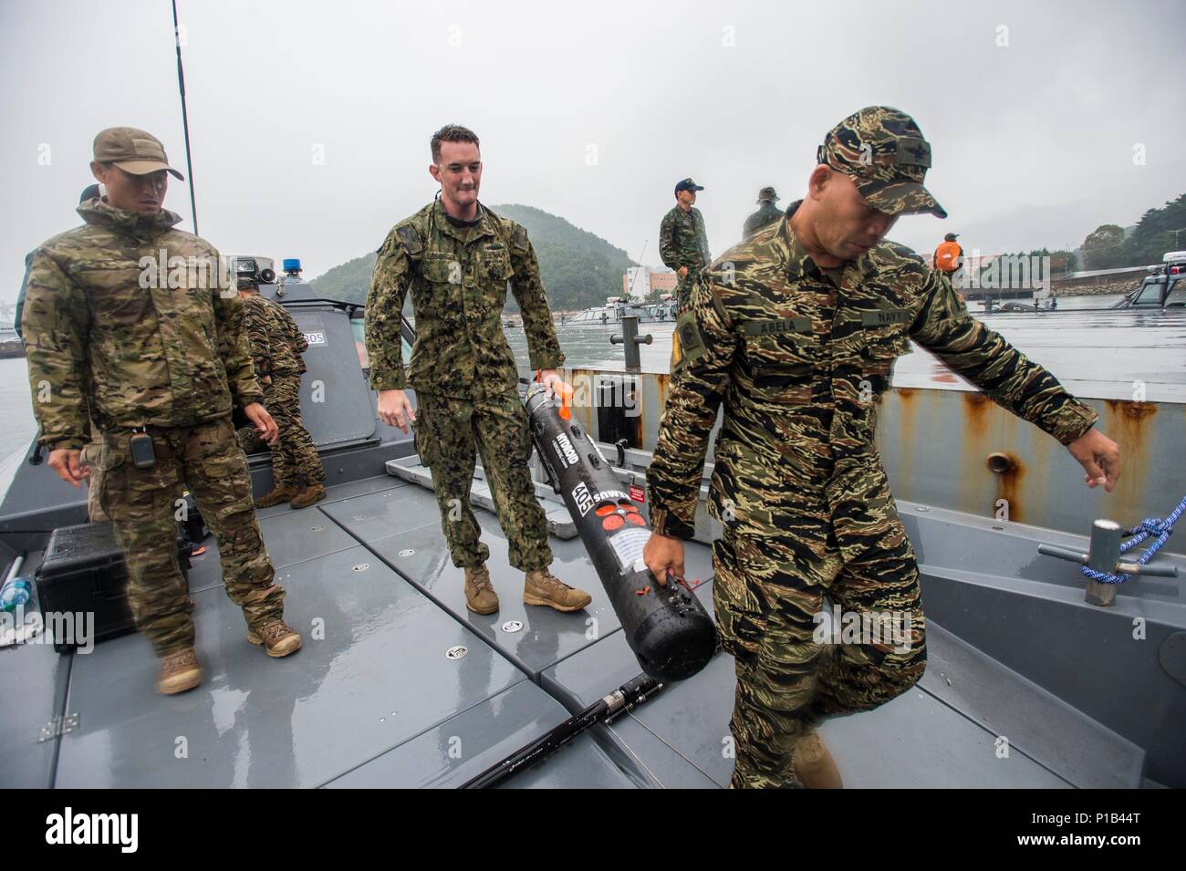 Petty Officer 3rd Class Steve Lissberger Center Assigned To Explosive Ordnance Disposal Mobile Unit 1 Carries The Mk 18 Mod 1 Unmanned Underwater Vehicle Uuv To The Water While Participating In Clear