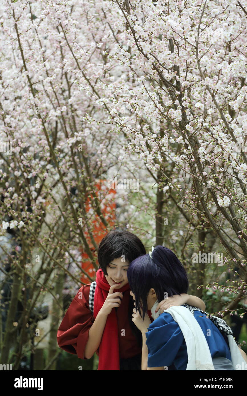 Two cosplay players posing for picture in front of the white sakura trees at Gardens By the Bay in Singapore. Stock Photo