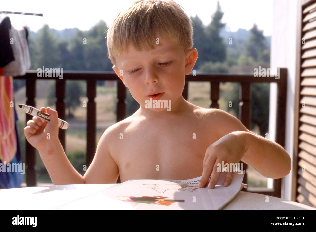 Young boy three years old drawing with a felt tip on holiday Stock Photo