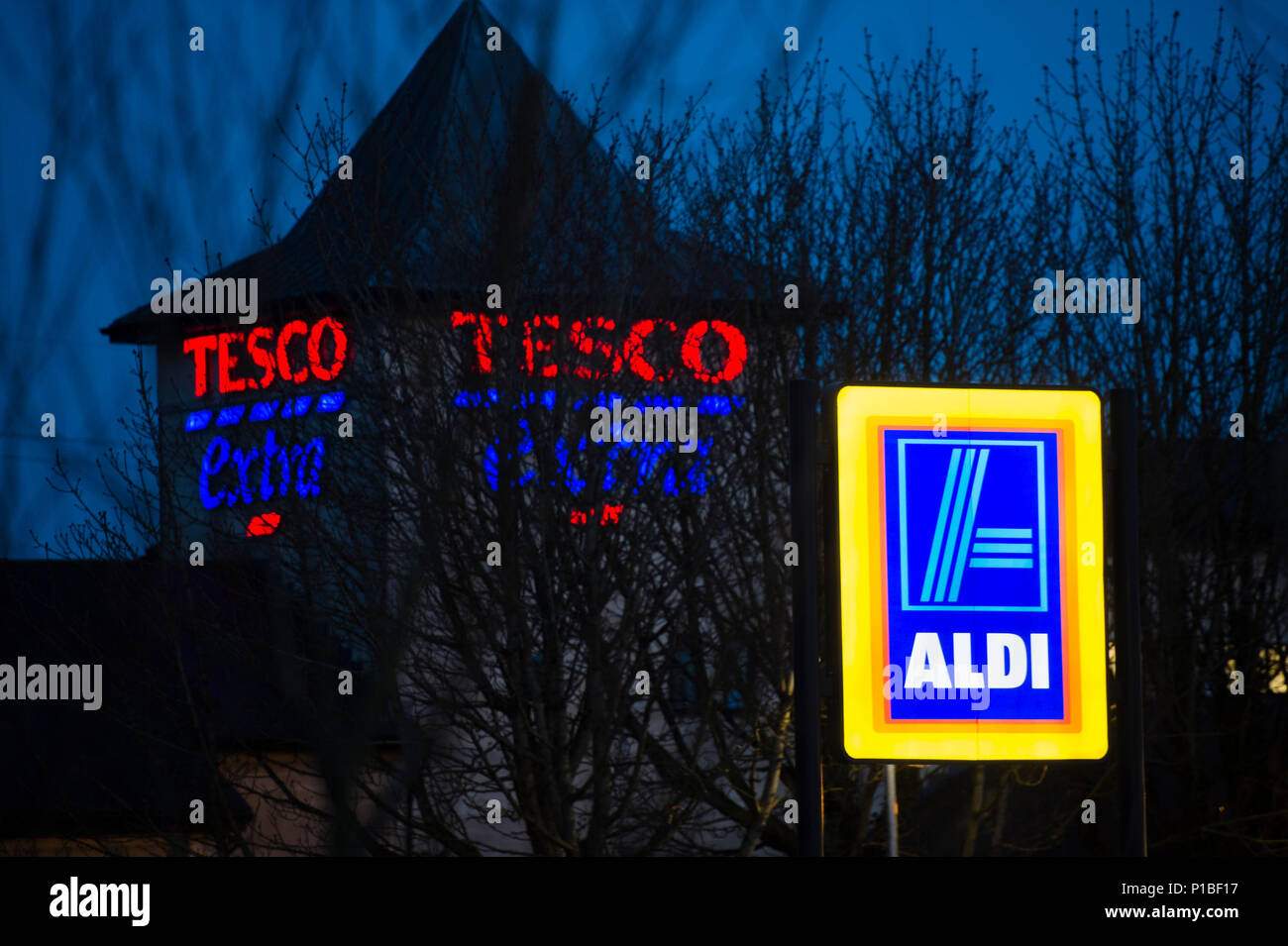 Aldi discount supermarket illuminated logo sign, with Tesco supernarket