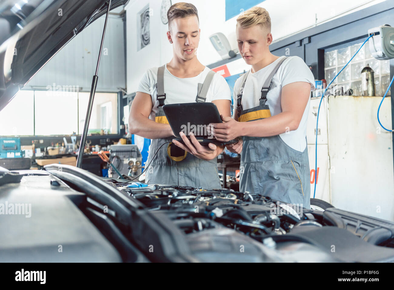 Experienced auto mechanic using a laptop for scanning engine errors Stock Photo