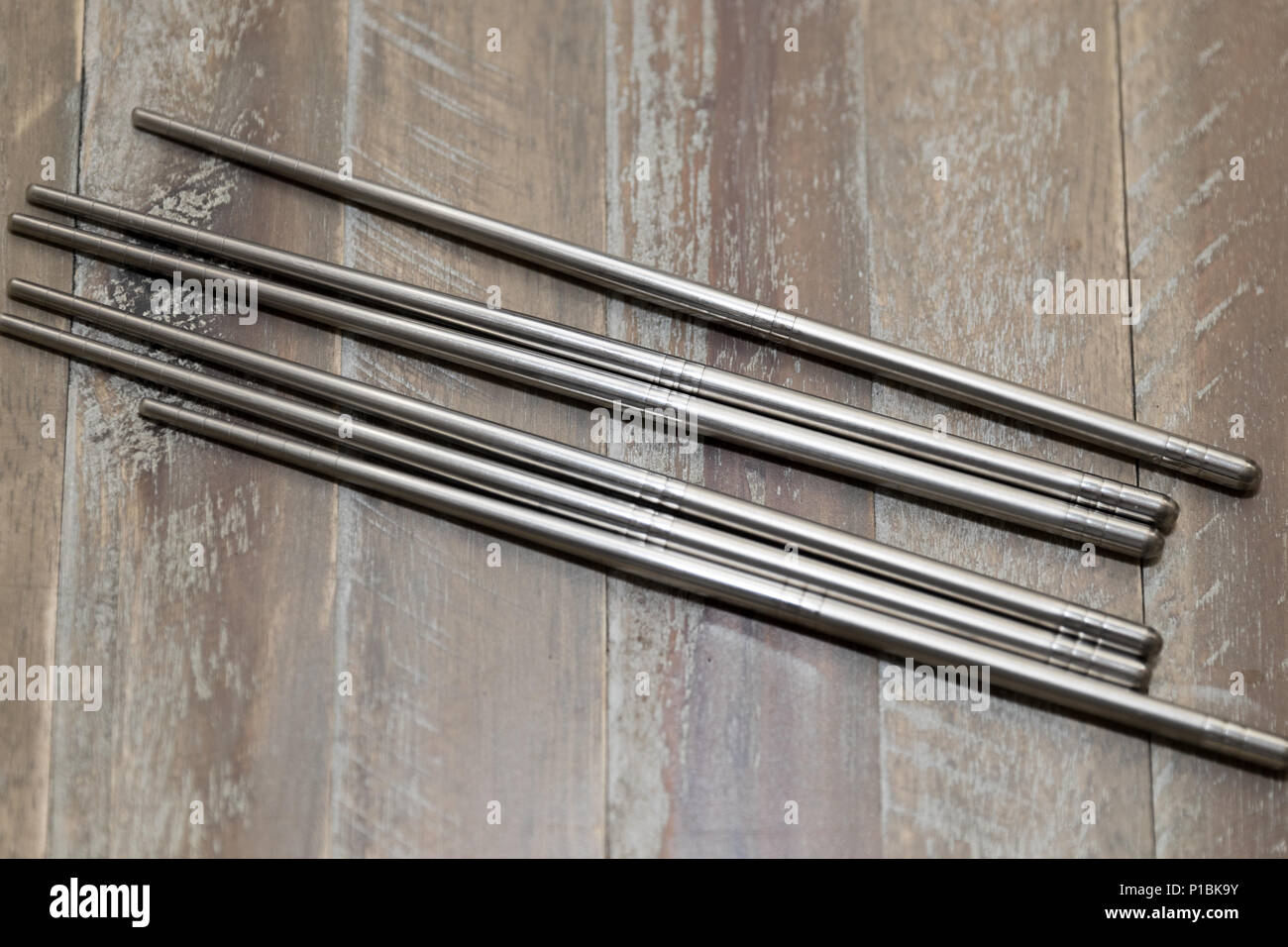 Metal chopsticks isolated on wooden background.Silver chopsticks