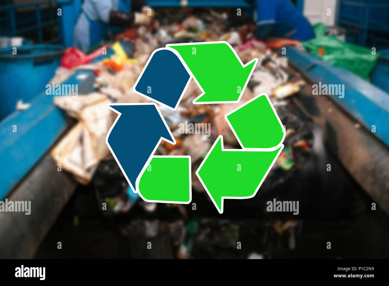 Sign recycling waste. The waste sorting and processing plant is blurry in the background Stock Photo