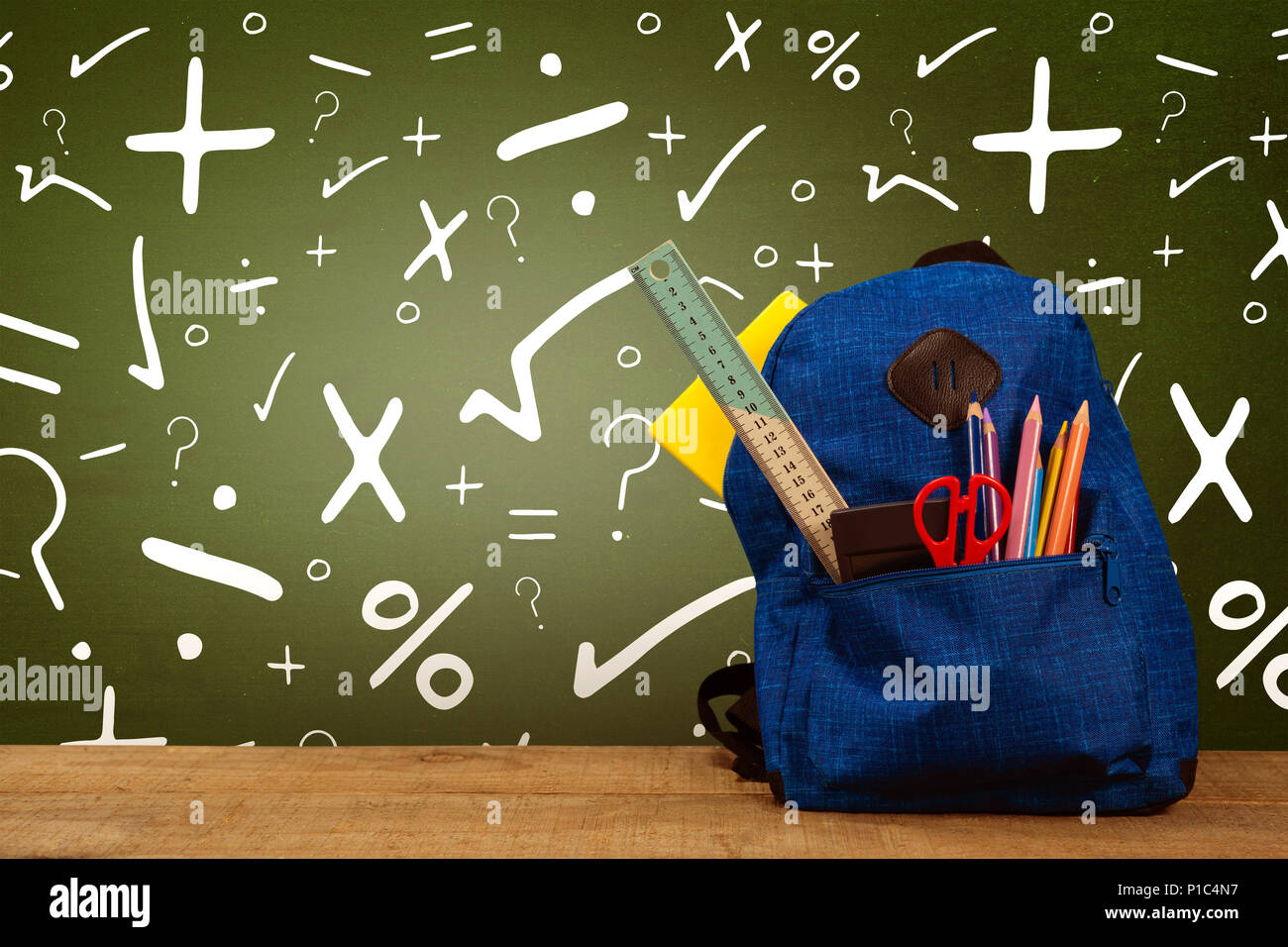 Composite image of schoolbag on wooden table Stock Photo