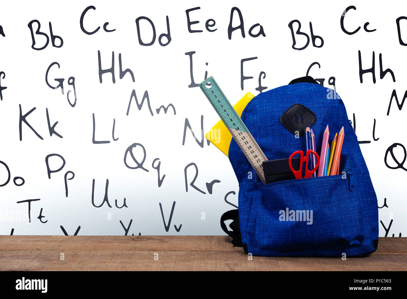 Schoolbag on wooden table Stock Photo